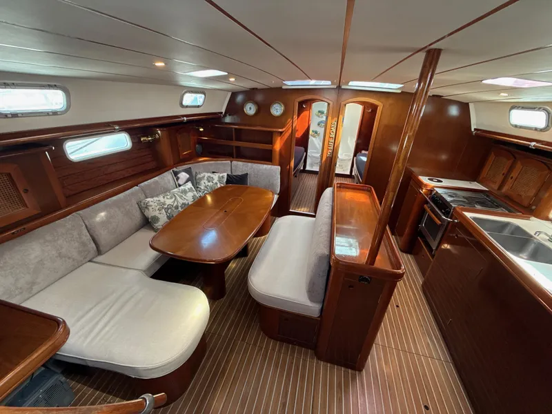 Slide: The Image of Interior of a 1997 Beneteau 50 yacht with elegant wood finish and cozy seating area. - 1