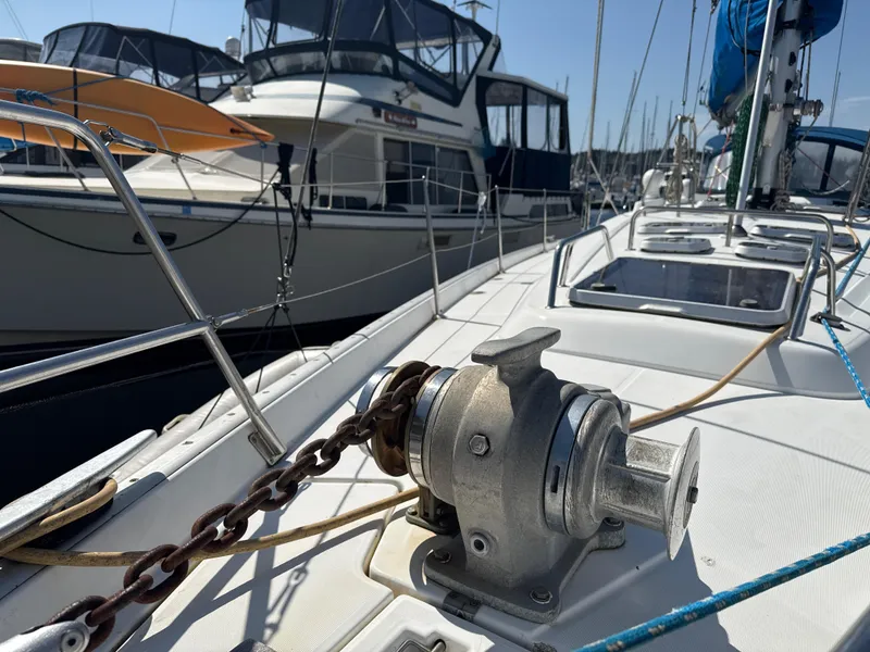 Slide: The Image of Beneteau 50 sailboat deck with anchor chain, docked alongside other boats, 1997 model. - 11