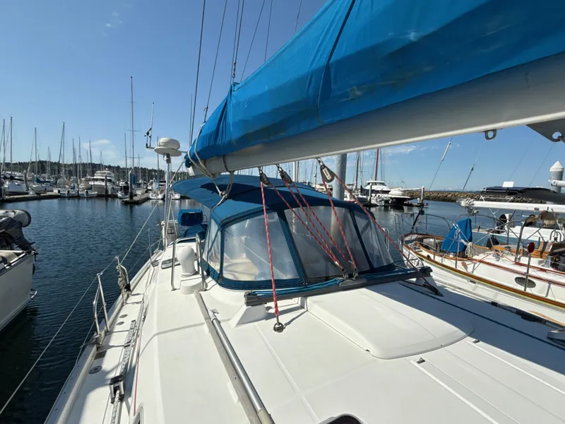 Slide: The Image of 1997 Beneteau 50 sailboat docked in marina, featuring blue sail cover and spacious deck. - 14