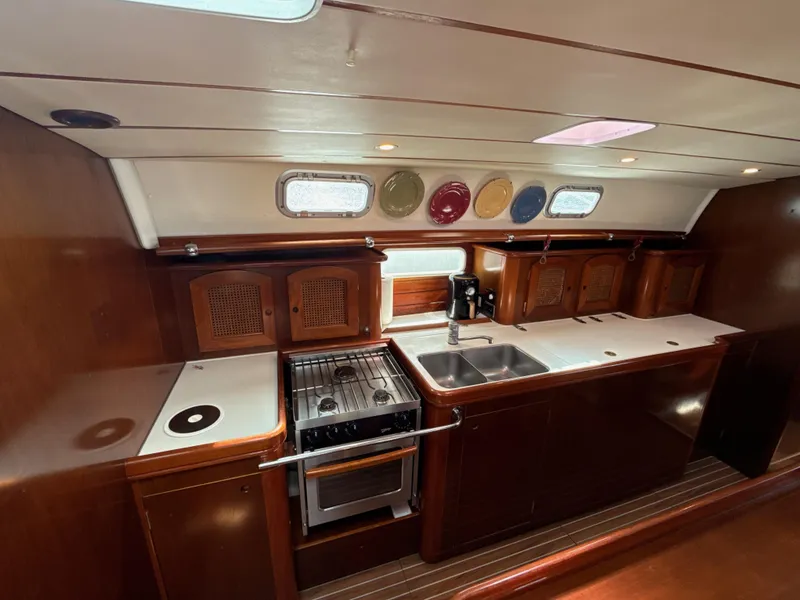 Slide: The Image of Interior of 1997 Beneteau 50 yacht kitchen with wood finish, stove, and sink. - 2