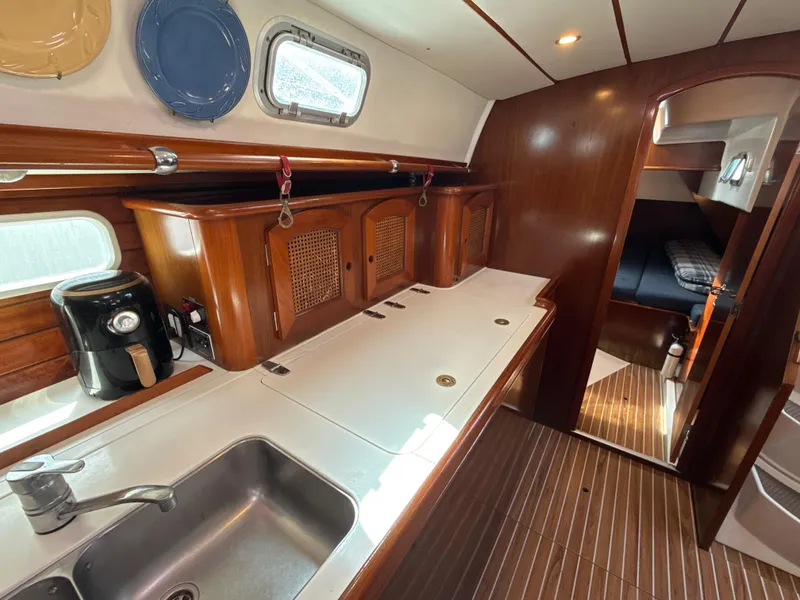 Slide: The Image of Interior of 1997 Beneteau 50 yacht with wooden cabinetry and modern kitchen amenities. - 28