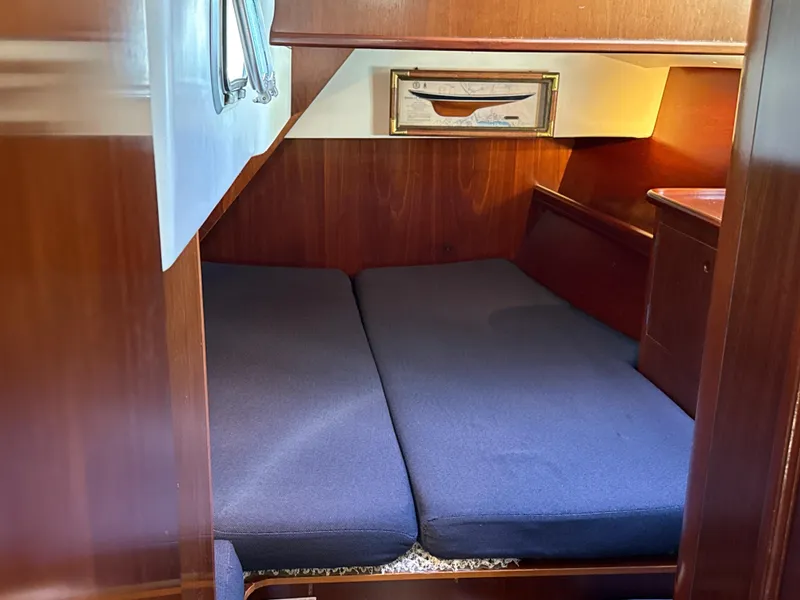 Slide: The Image of Cozy cabin interior of a 1997 Beneteau 50 sailboat with blue cushions and wooden finish. - 30