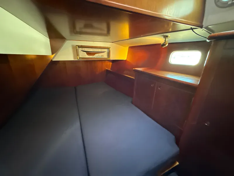 Slide: The Image of Cozy cabin interior of 1997 Beneteau 50 sailboat with wooden furnishings and window. - 32