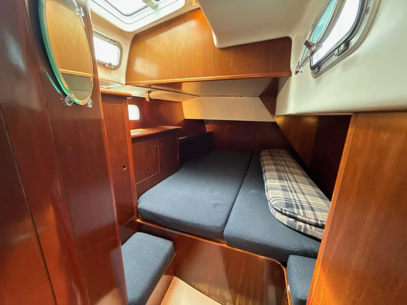 Slide: The Image of Cozy cabin interior of a 1997 Beneteau 50 sailboat with wooden finishes and bedding. - 33