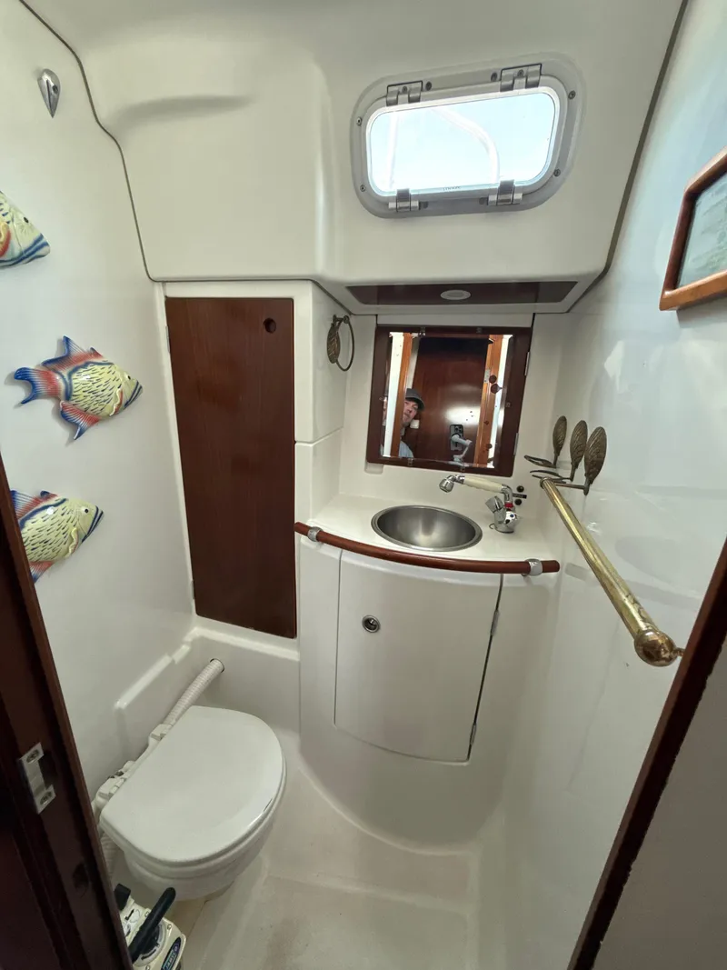 Slide: The Image of Bathroom interior of a 1997 Beneteau 50 yacht, featuring sink, toilet, and nautical decor. - 35