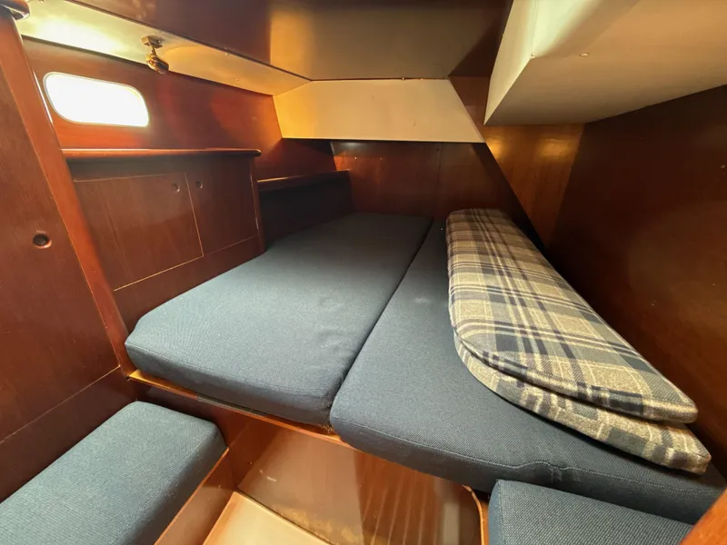 Slide: The Image of Cozy cabin interior of 1997 Beneteau 50 sailboat with blue cushions and plaid blanket. - 39