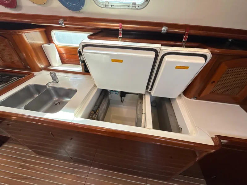 Slide: The Image of 1997 Beneteau 50 yacht kitchen with double sink and open storage compartments. - 4