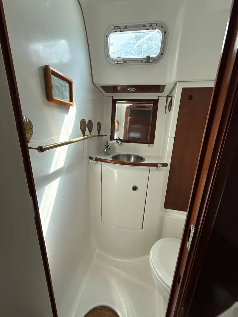 Slide: The Image of Compact bathroom in a 1997 Beneteau 50 yacht, featuring a sink and porthole window. - 42