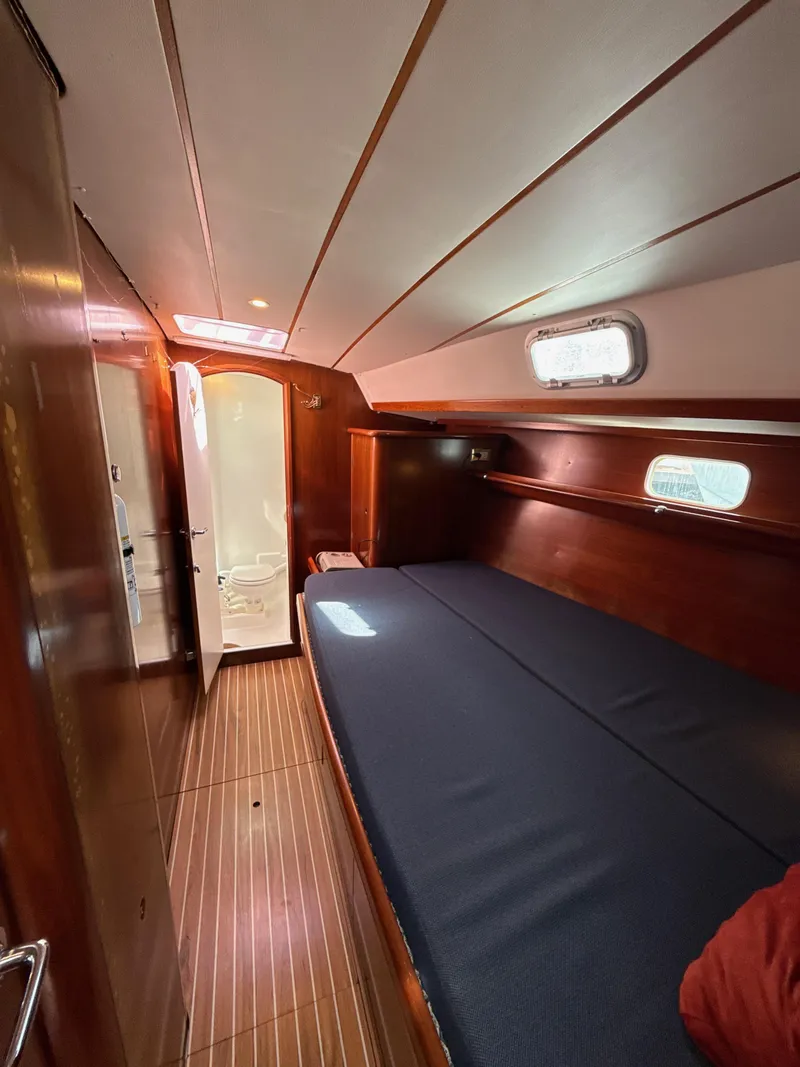 Slide: The Image of 1997 Beneteau 50 yacht cabin with wooden interior and cozy bed. - 43