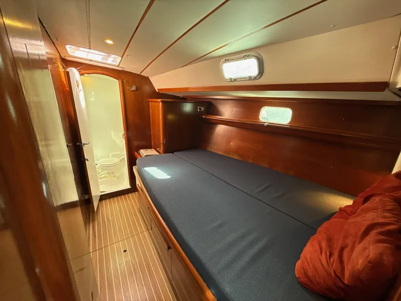 Slide: The Image of Cozy cabin interior of a 1997 Beneteau 50 sailboat with wooden finishes and a comfortable bed. - 44