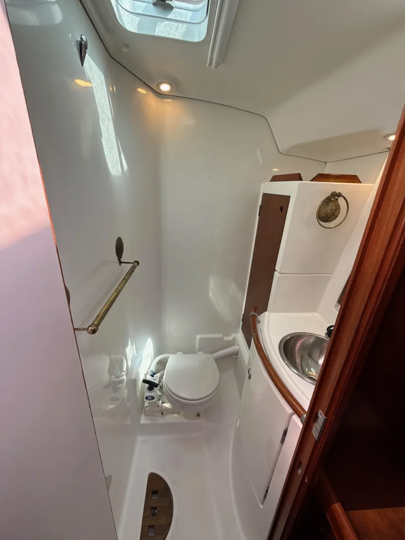 Slide: The Image of 1997 Beneteau 50 yacht bathroom with toilet, sink, and skylight. - 46