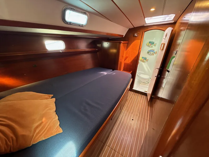 Slide: The Image of Cozy cabin interior of a 1997 Beneteau 50 sailboat with wooden finishes and a comfortable bed. - 47