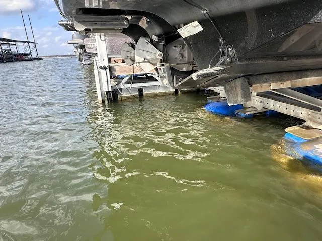 Slide: The Image of 2012 Yamaha Boats 242 Limited S on lift, partially submerged in water. - 24