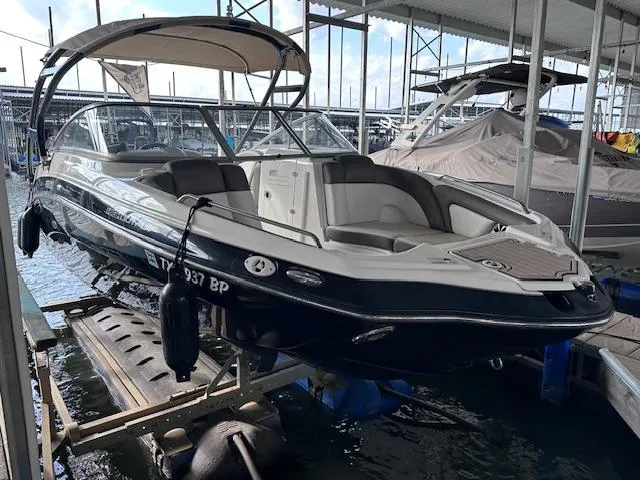 Slide: The Image of 2012 Yamaha Boats 242 Limited S docked in a marina, featuring sleek design and spacious seating. - 4