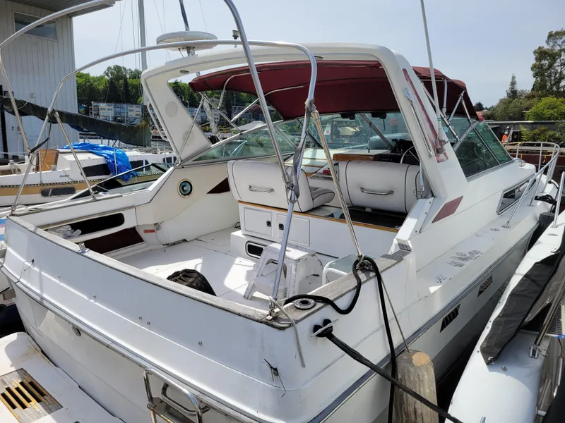 The Image of 1989 Sea Ray 340 Sundancer boat docked, featuring spacious deck and maroon canopy. - 0