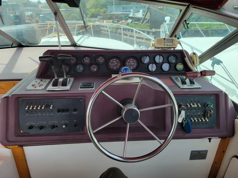 Slide: The Image of 1989 Sea Ray 340 Sundancer helm with steering wheel, gauges, and controls. - 10