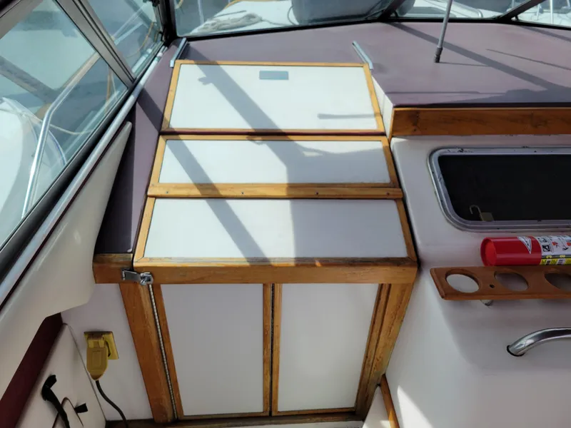 Slide: The Image of 1989 Sea Ray 340 Sundancer cabin interior with wooden cabinetry and fire extinguisher. - 18