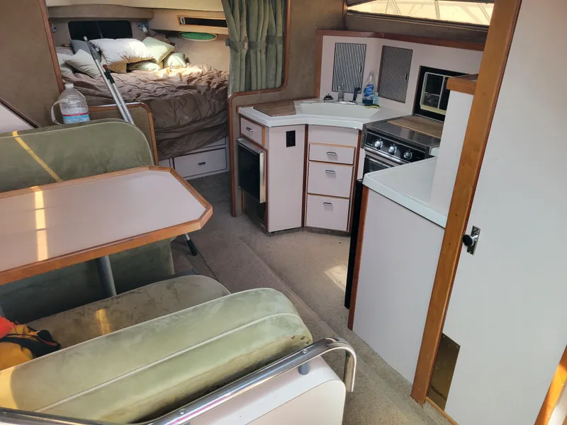 Slide: The Image of 1989 Sea Ray 340 Sundancer interior with kitchen, dining area, and bed. - 20