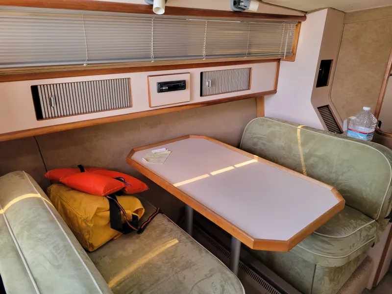 Slide: The Image of 1989 Sea Ray 340 Sundancer cabin interior with table, seating, and life jackets. - 24