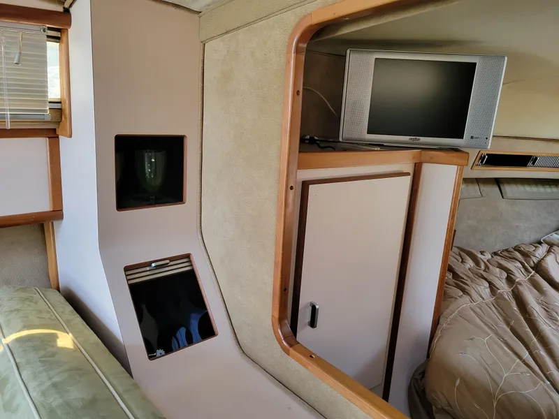 Slide: The Image of Interior of 1989 Sea Ray 340 Sundancer with TV, storage, and bed. - 25