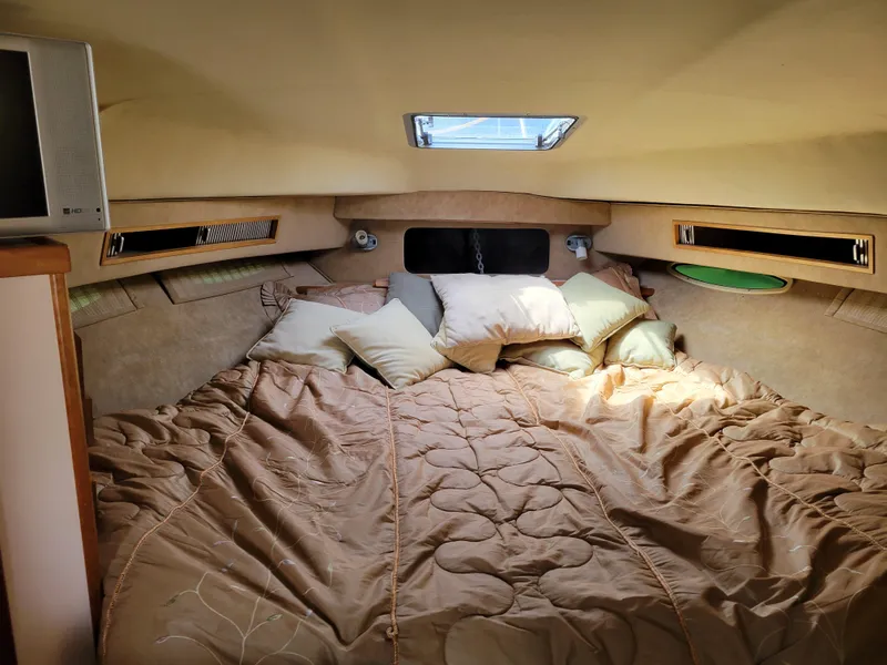 Slide: The Image of Cozy cabin interior of 1989 Sea Ray 340 Sundancer with bed and pillows. - 26