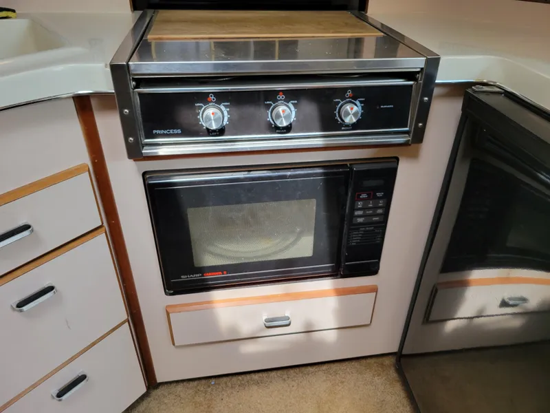 Slide: The Image of 1989 Sea Ray 340 Sundancer kitchen with stove and microwave. - 31