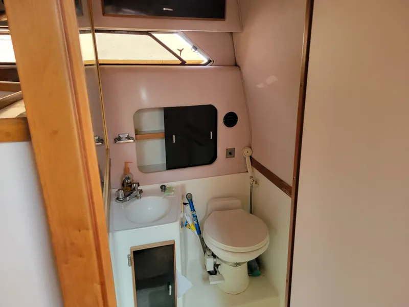Slide: The Image of Interior of 1989 Sea Ray 340 Sundancer bathroom with sink and toilet. - 34