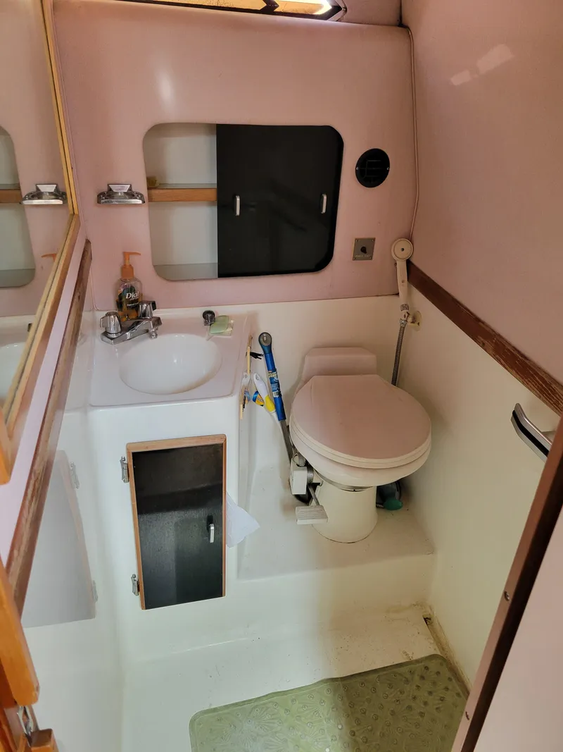 Slide: The Image of 1989 Sea Ray 340 Sundancer bathroom with sink, toilet, and storage cabinet. - 35