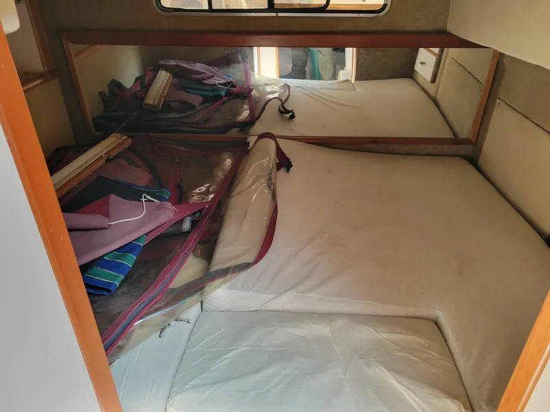 Slide: The Image of 1989 Sea Ray 340 Sundancer cabin interior with bed and storage space. - 36