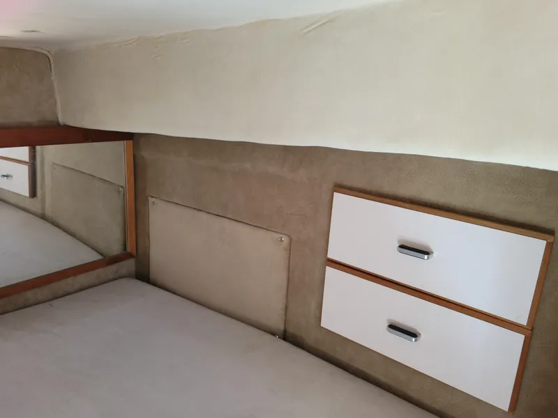 Slide: The Image of Interior of 1989 Sea Ray 340 Sundancer with beige walls and white drawers. - 38