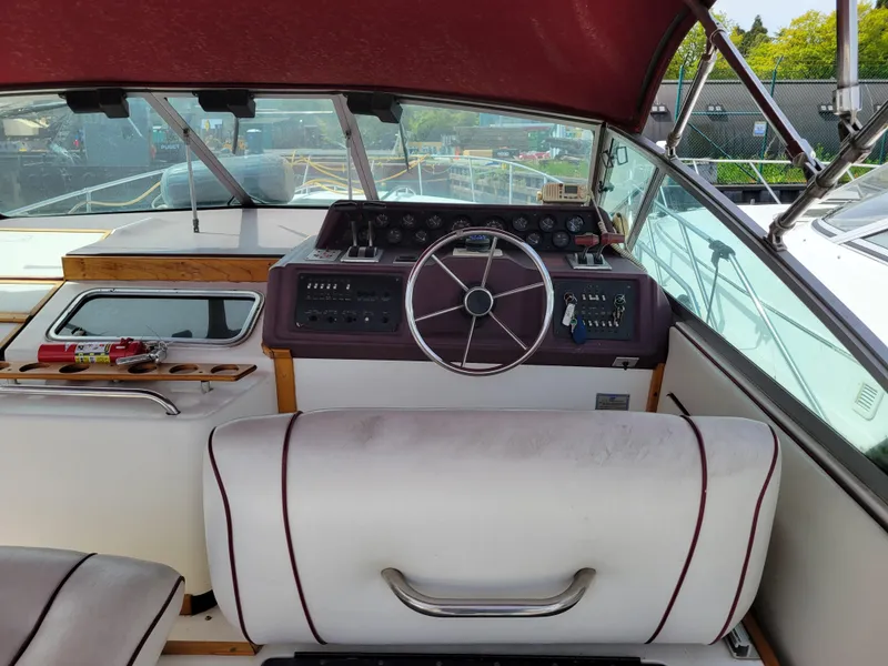 Slide: The Image of 1989 Sea Ray 340 Sundancer helm with maroon dashboard and steering wheel, featuring classic design elements. - 8