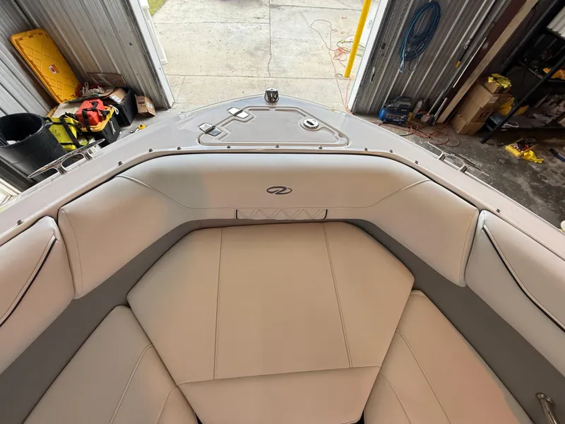 Slide: The Image of 2024 Regal LX2 boat interior with beige seating in a garage setting. - 12