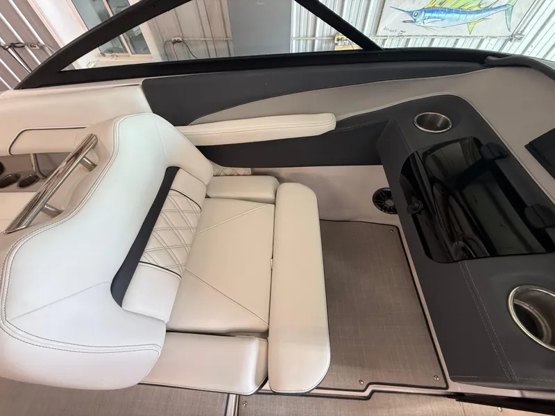 Slide: The Image of 2024 Regal LX2 boat interior with white leather seating and cup holders. - 13