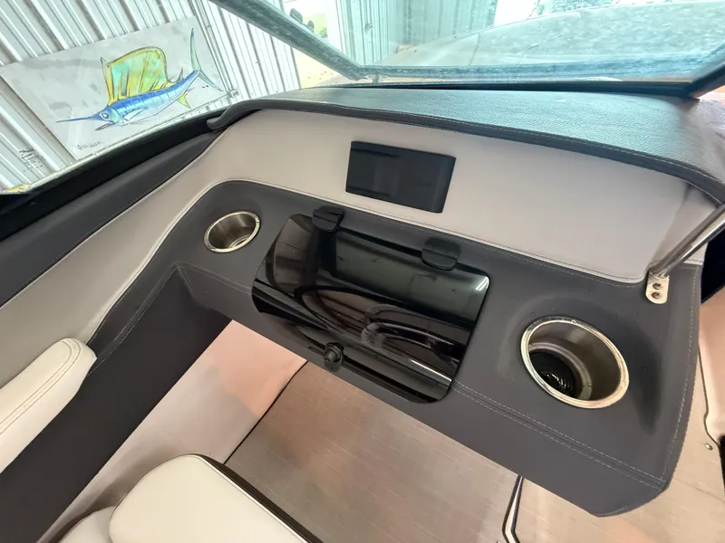Slide: The Image of 2024 Regal LX2 boat interior with sleek dashboard and cup holders. - 14