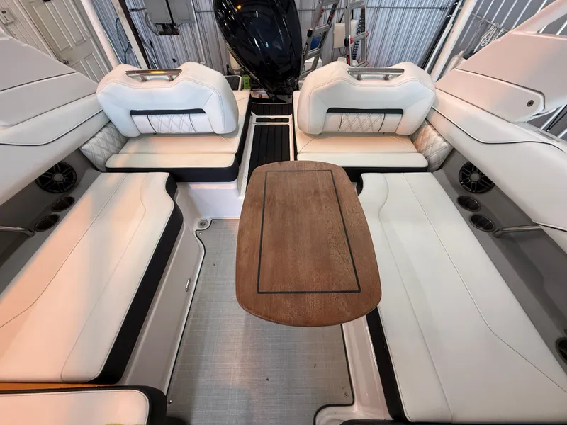 Slide: The Image of 2024 Regal LX2 boat interior with white seating and wooden table. - 16