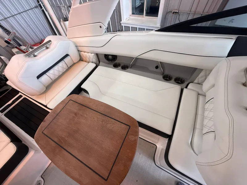 Slide: The Image of 2024 Regal LX2 boat interior with white seating and wooden table. - 25