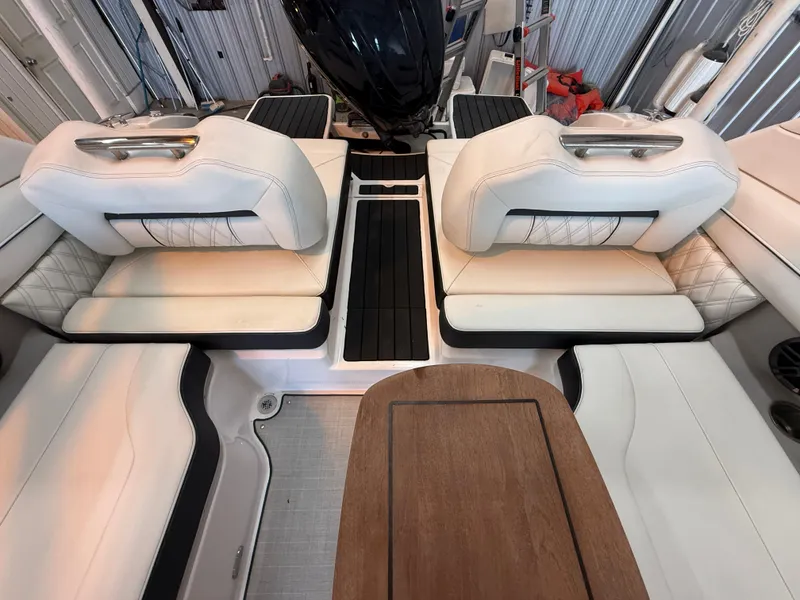 Slide: The Image of 2024 Regal LX2 boat interior with white leather seats and wooden table. - 26