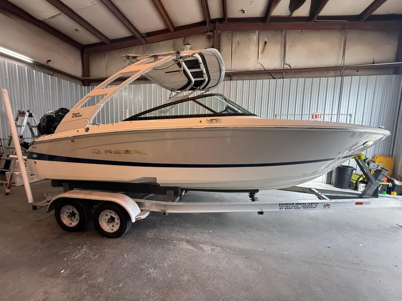 Slide: The Image of 2024 Regal LX2 boat on trailer in a metal garage. - 3