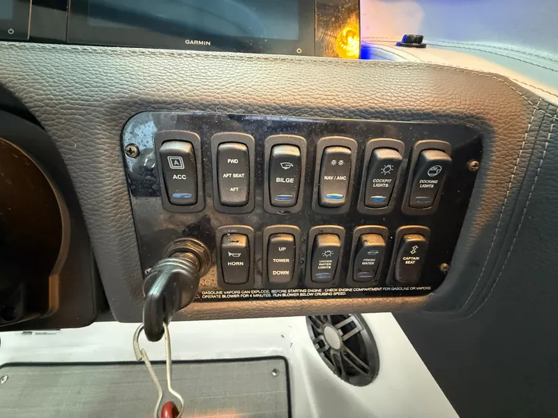 Slide: The Image of Control panel of a 2024 Regal LX2 boat with various switches and key ignition. - 30