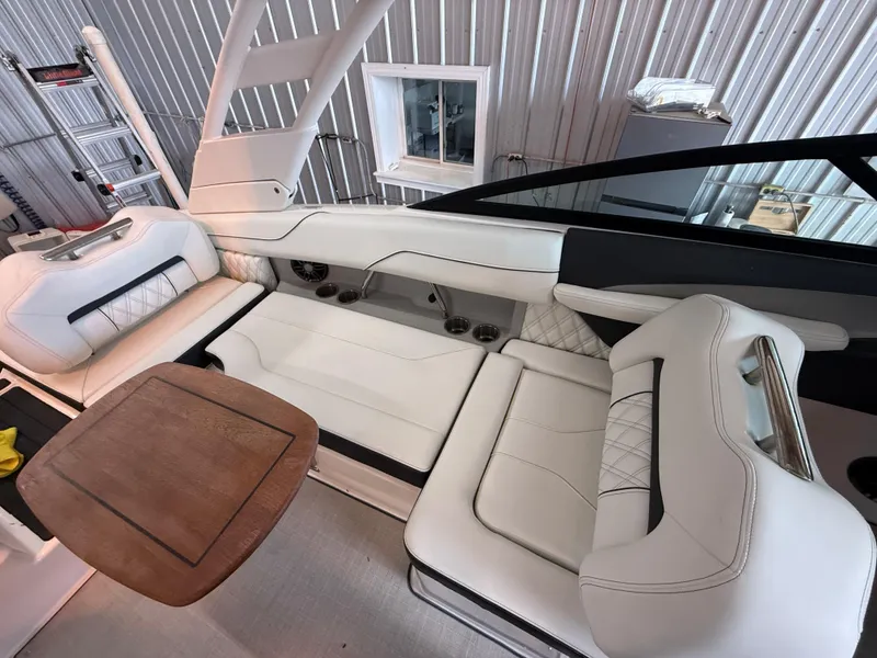 Slide: The Image of 2024 Regal LX2 boat interior with white leather seating and wooden table. - 32