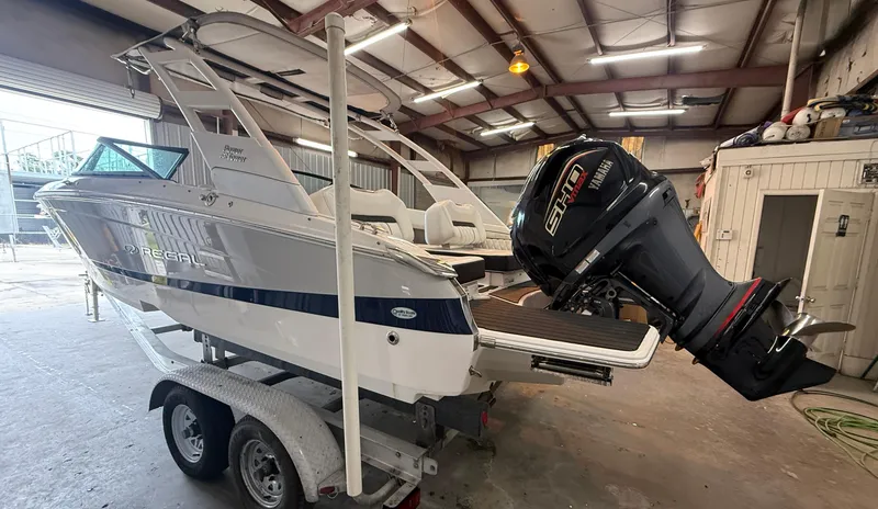 Slide: The Image of 2024 Regal LX2 boat on trailer in warehouse, featuring powerful outboard motor. - 6