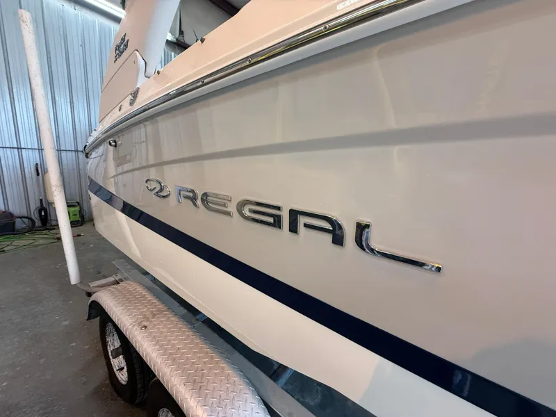 Slide: The Image of 2024 Regal LX2 boat on trailer in a garage setting. - 7