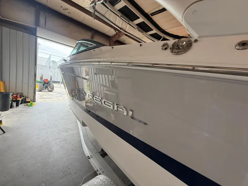 Slide: The Image of 2024 Regal LX2 boat in a garage, showcasing sleek design and branding. - 8