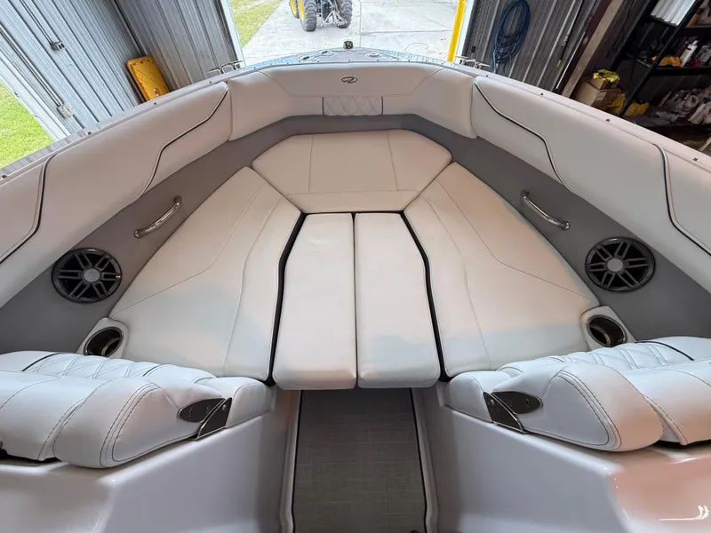 Slide: The Image of 2024 Regal LX2 boat interior with white cushioned seating and built-in speakers. - 9