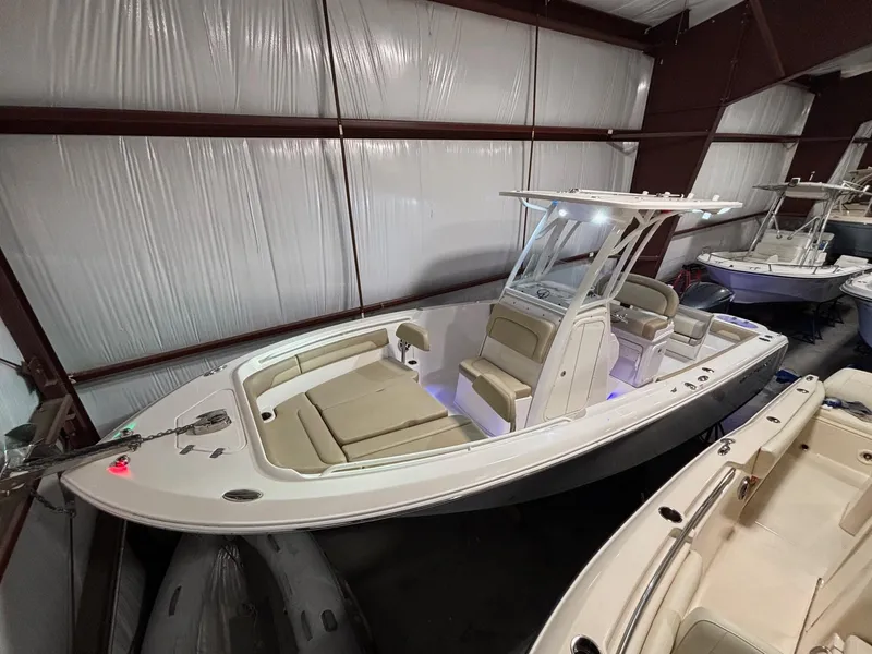 Slide: The Image of 2019 Sailfish 241 CC boat in indoor storage, featuring sleek design and comfortable seating. - 0