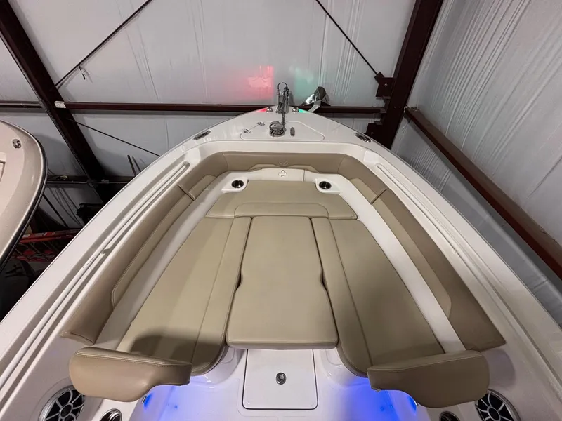 Slide: The Image of 2019 Sailfish 241 CC boat interior with beige seating and blue LED lighting. - 14