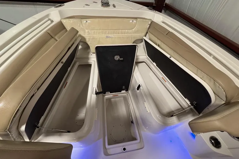 Slide: The Image of 2019 Sailfish 241 CC boat interior with beige seating and storage compartments. - 15