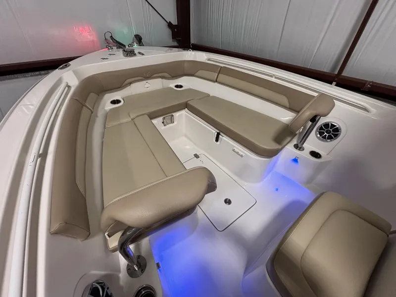 Slide: The Image of 2019 Sailfish 241 CC boat interior with beige seating and blue LED lighting. - 17