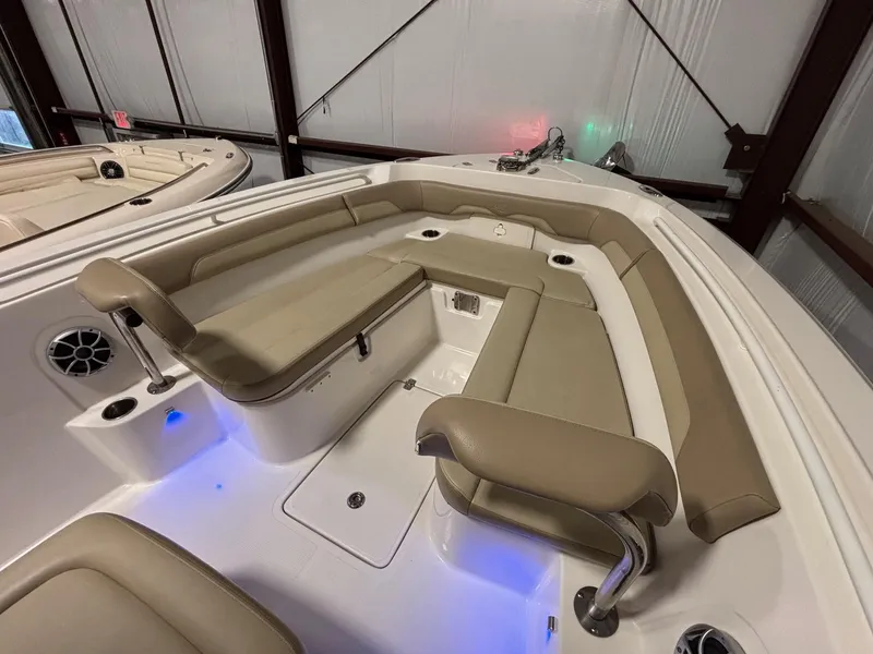 Slide: The Image of 2019 Sailfish 241 CC boat interior with beige seating and blue LED lighting. - 18