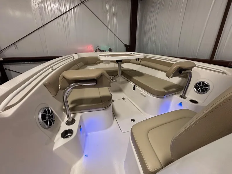Slide: The Image of 2019 Sailfish 241 CC boat interior with beige seating and blue LED lighting. - 19
